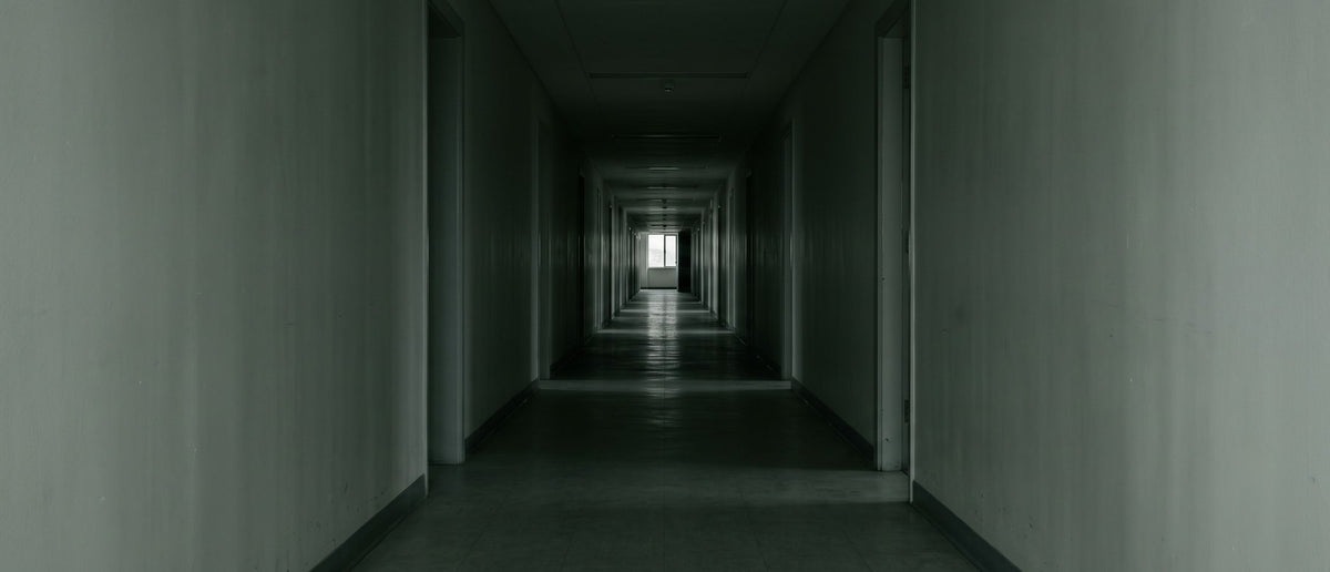 Empty corridor with light at the far end